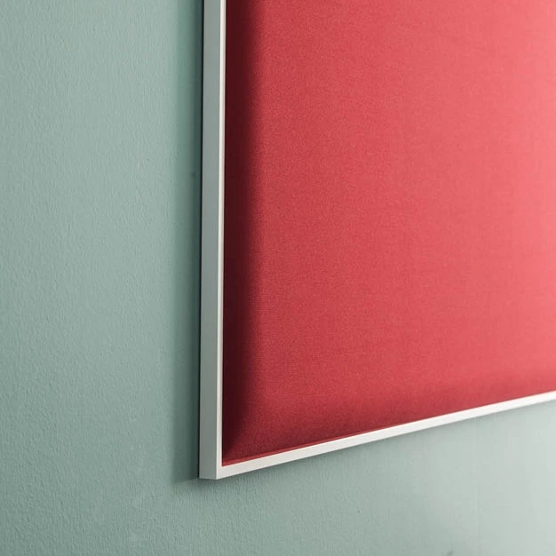Cadre acoustique rouge accroché sur un mur bleu