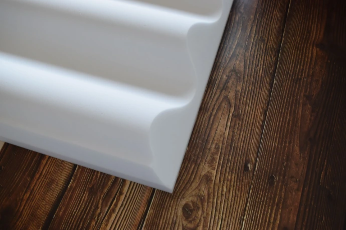Panneau en mousse de mélamine ondulé déposé sur une table en bois