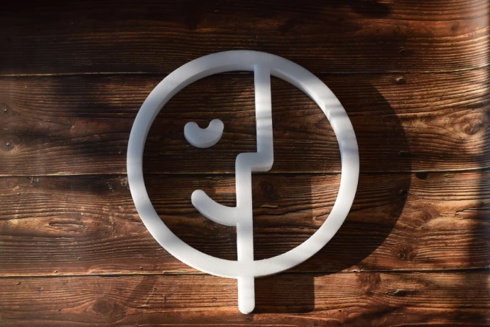 Logo Regulo en mousse de mélamine déposé sur une table en bois