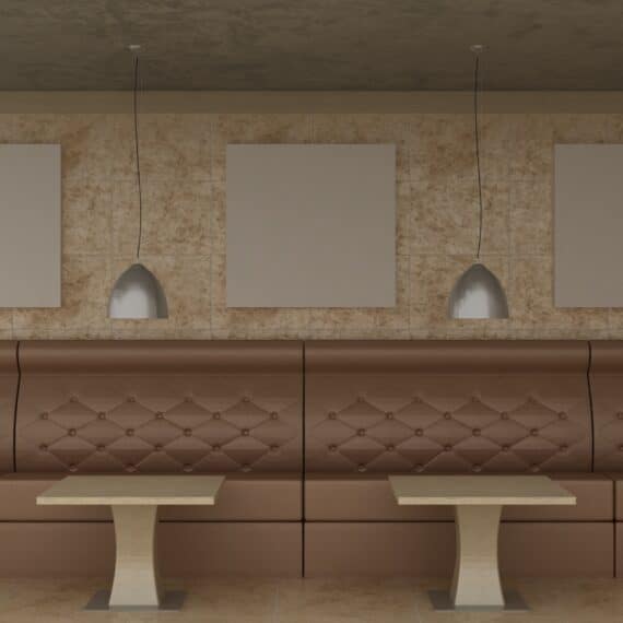 Cadres vides dans un décor de café classique sur un mur décoratif avec sol en marbre. Canapé, table et lustre de café.